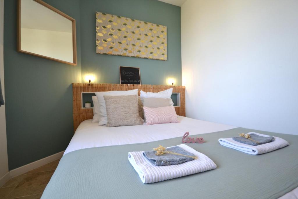 ein Schlafzimmer mit einem Bett mit Handtüchern darauf in der Unterkunft L'Emoustillant jacuzzi, unique et hors du temps in La Richardais