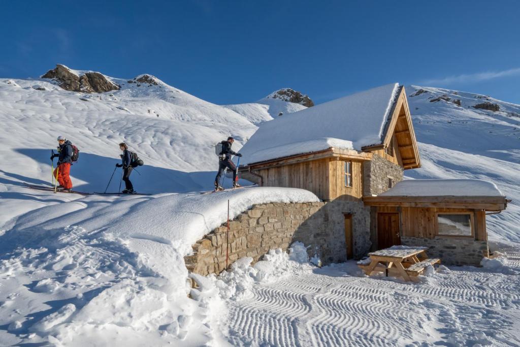 three people on skis standing on top of a building in the snow at Le Refuge Ibex - Chalet d'Alpage au coeur de la nature - 8 personnes in Orcières