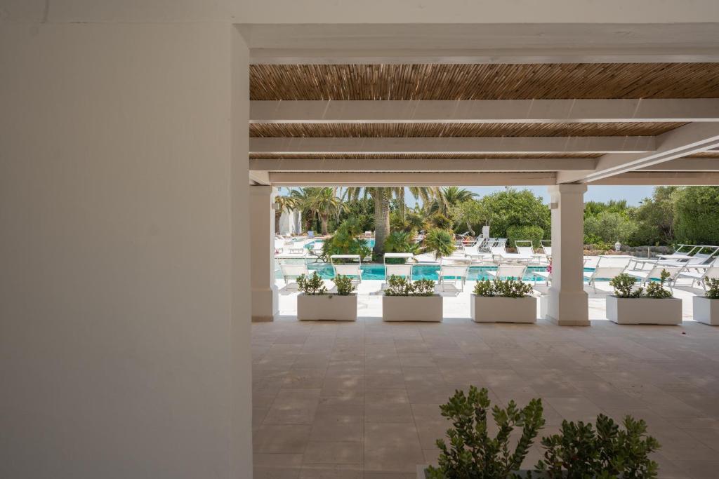 a patio at a resort withotted plants and a pool at Ostuni a Mare in Ostuni