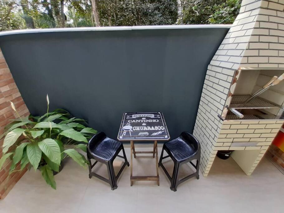 eine Terrasse mit 3 Stühlen und einem Tisch mit Schild in der Unterkunft Stúdio Natureza S/A 2 in Bombinhas