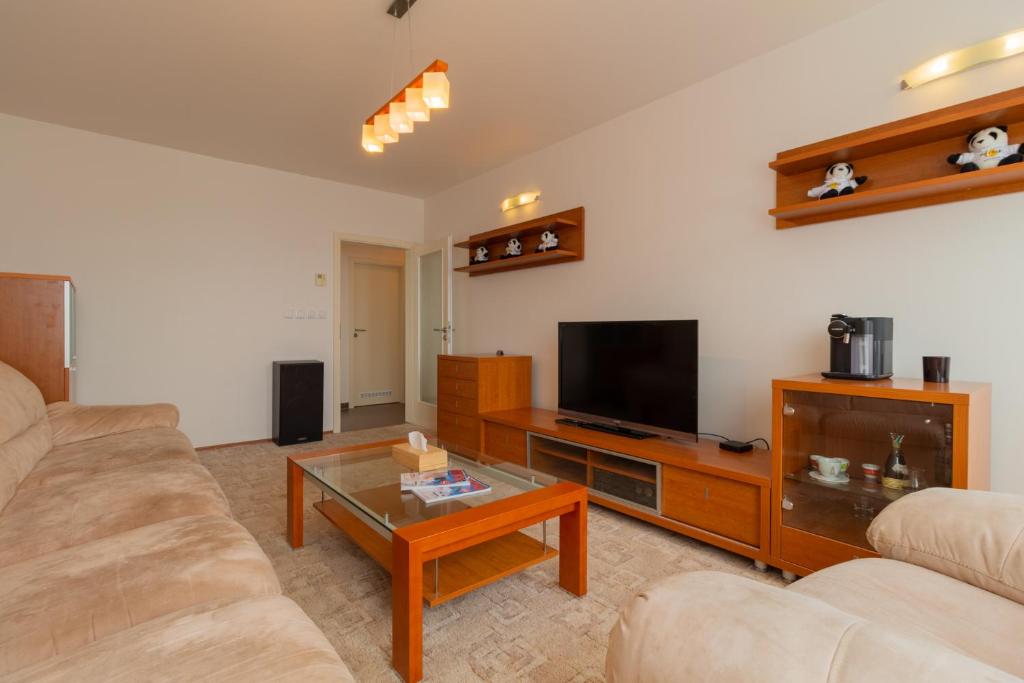 a living room with a couch and a flat screen tv at Residence Le Mont in Trutnov
