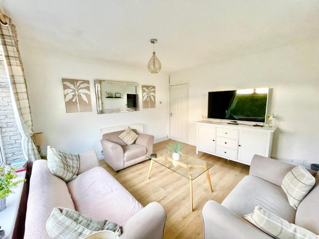 a living room with a couch and a tv at South Stack Bungalow in Holyhead