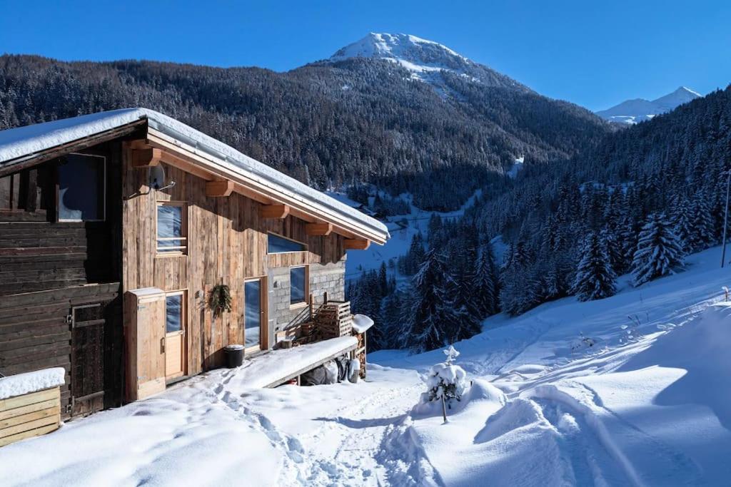 ein Blockhaus im Schnee neben einem Berg in der Unterkunft La Plagne Tarentaise : Chalet Mériers in La Plagne Tarentaise