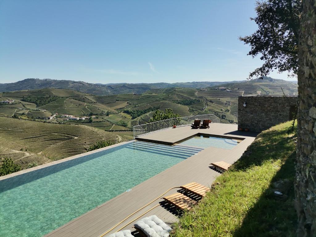a swimming pool with a view of the hills at Quinta de Travassinhos- Douro Valley in Santa Marta de Penaguião