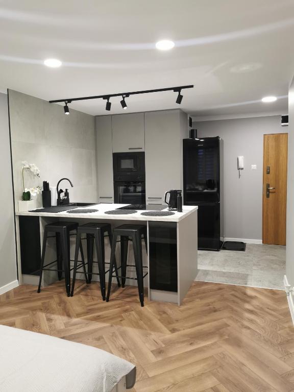 a kitchen with a table and black and white appliances at Apartament w Centrum Tarnowa Lwowska in Tarnów