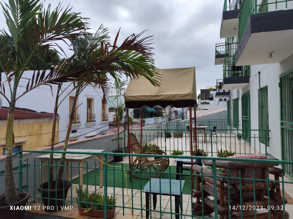 een balkon met een tafel en palmbomen op een gebouw bij Aparthotel Genova in Santo Domingo