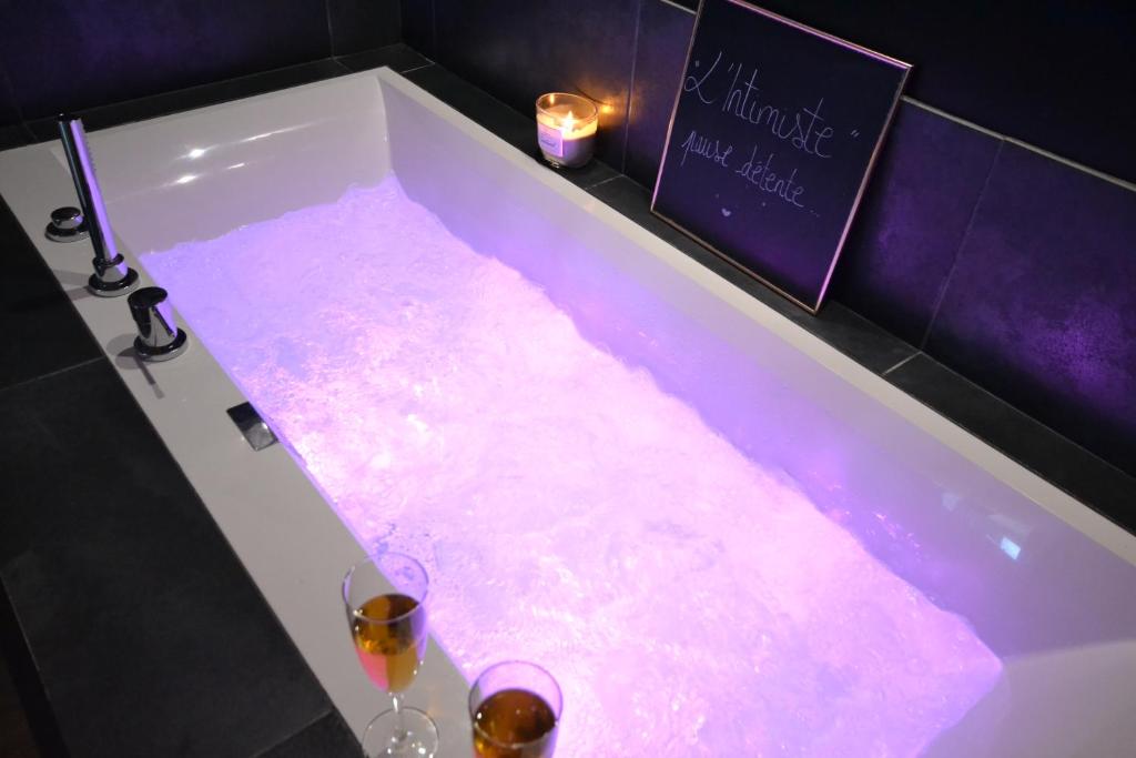 una vasca da bagno con due bicchieri di vino di L'Intimiste Balnéo Spa, pure détente et romantisme a La Richardais
