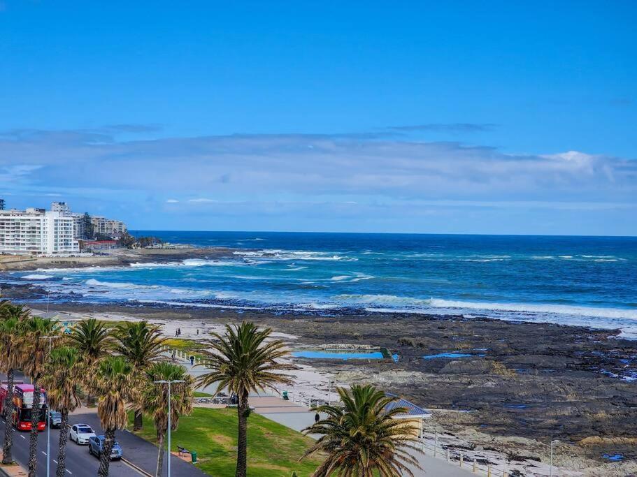 a view of a beach with palm trees and the ocean at Spacious family Apartment Near Beach with Inverter in Cape Town