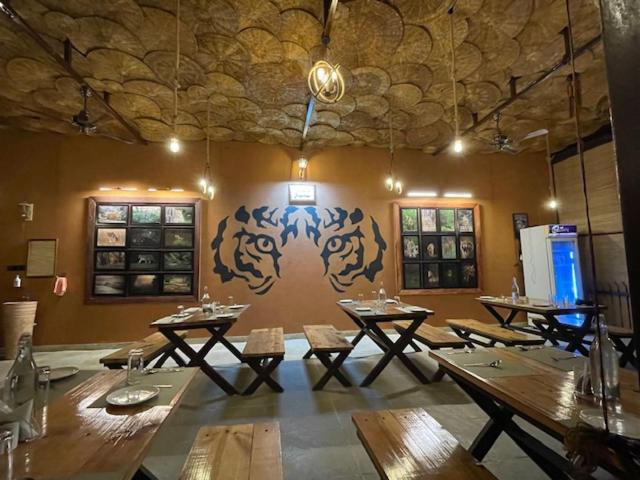 un comedor con mesas de madera y una pared con un mural en VANN VAIKUNTHAM, en Khawāsa