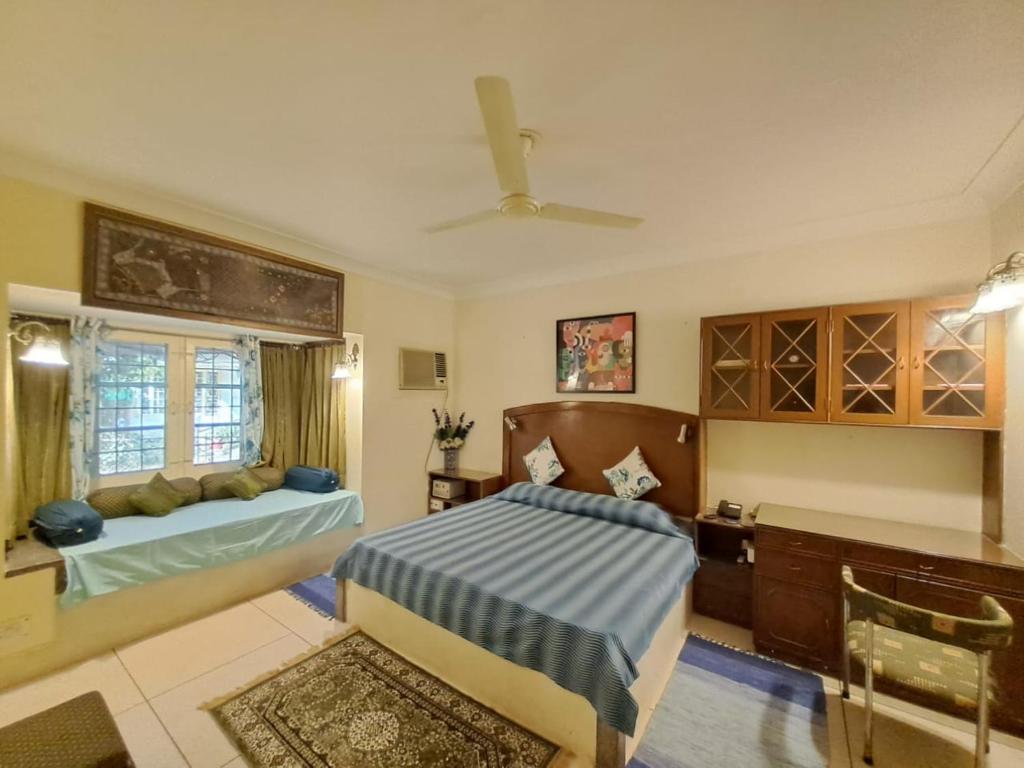 1 dormitorio con cama, escritorio y ventana en Vijaya's Homestead Jaipur, en Jaipur