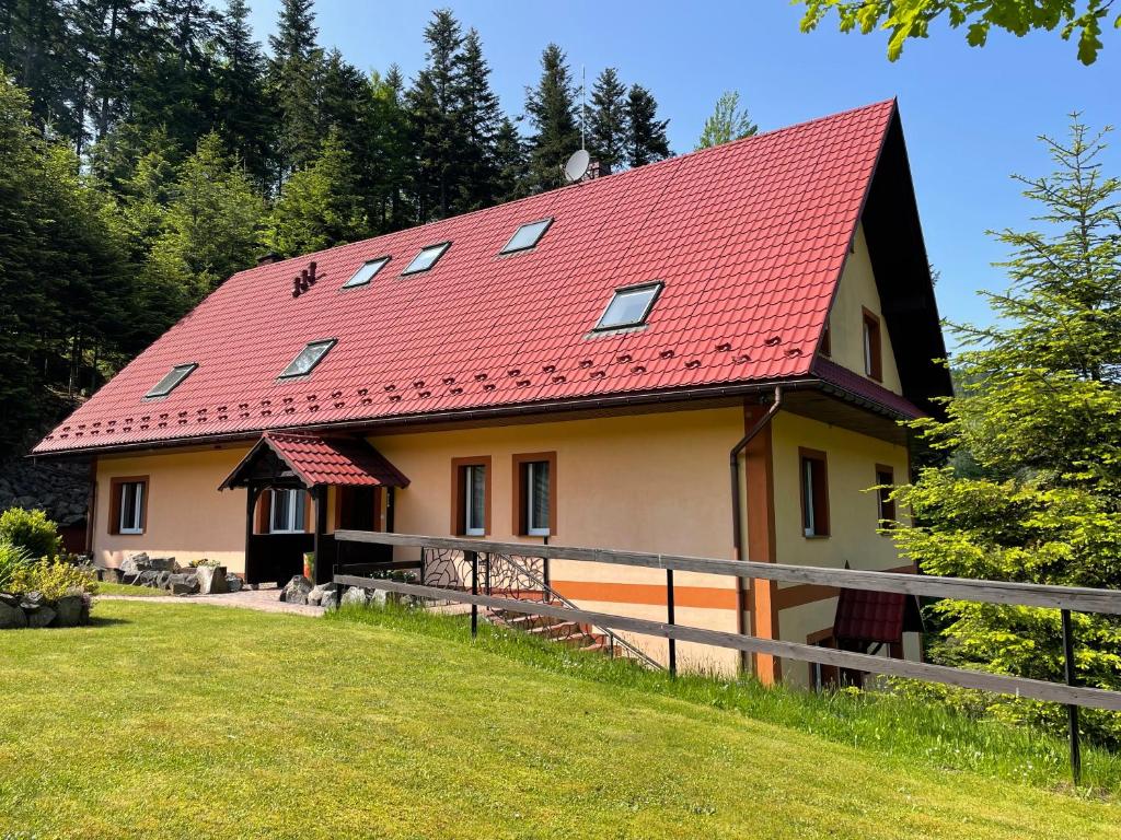 ein Haus mit rotem Dach auf einem Hügel in der Unterkunft Willa Arga in Piwniczna-Zdrój