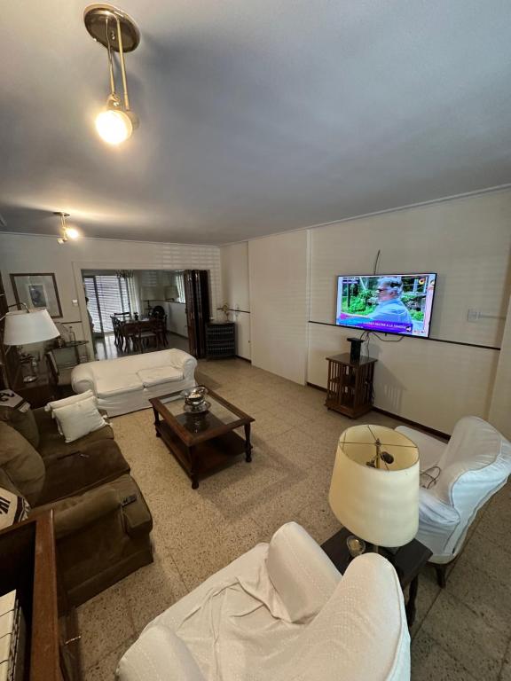 uma sala de estar com sofás e uma televisão de ecrã plano em CASA BOMBAL em Mendoza