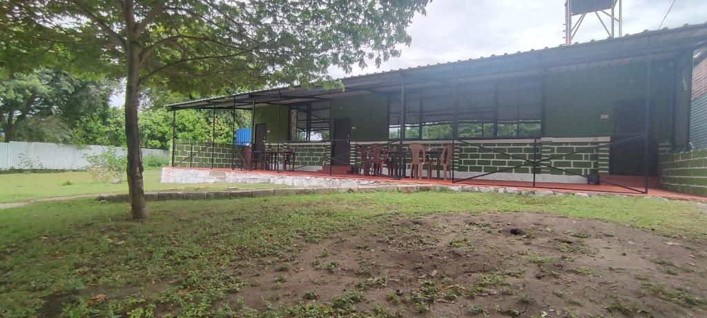 a building with a table and chairs in a yard at Wild tusker in Masinagudi