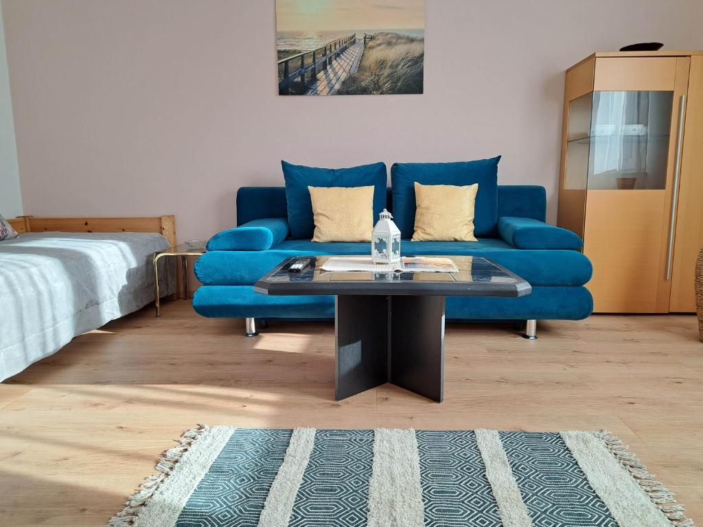 a living room with a blue couch and a table at Appartement Eigelsreiter Lindwurm in Traisen