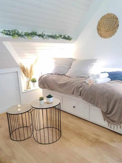 um quarto com uma cama e duas mesas em Studio Coquet - Comme à la maison - Loïc Nantes em Sautron