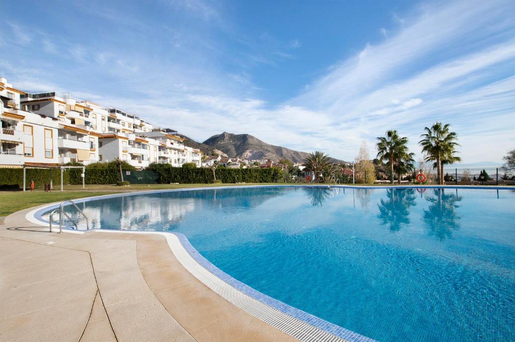 a large blue swimming pool in front of some buildings at Benalmarina in Benalmádena