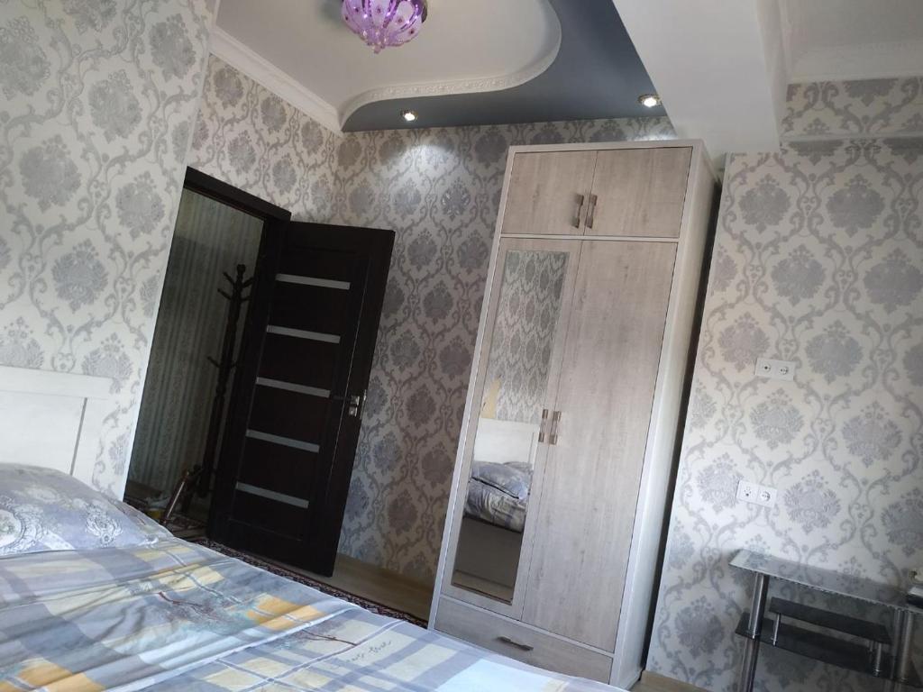 een slaapkamer met een bed, een spiegel en een kast bij Yunusobod kvartira. Medical center 