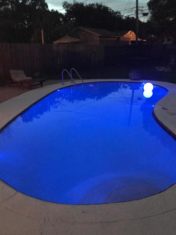 a large blue pool with lights in a backyard at La Adventura Villa in Seminole