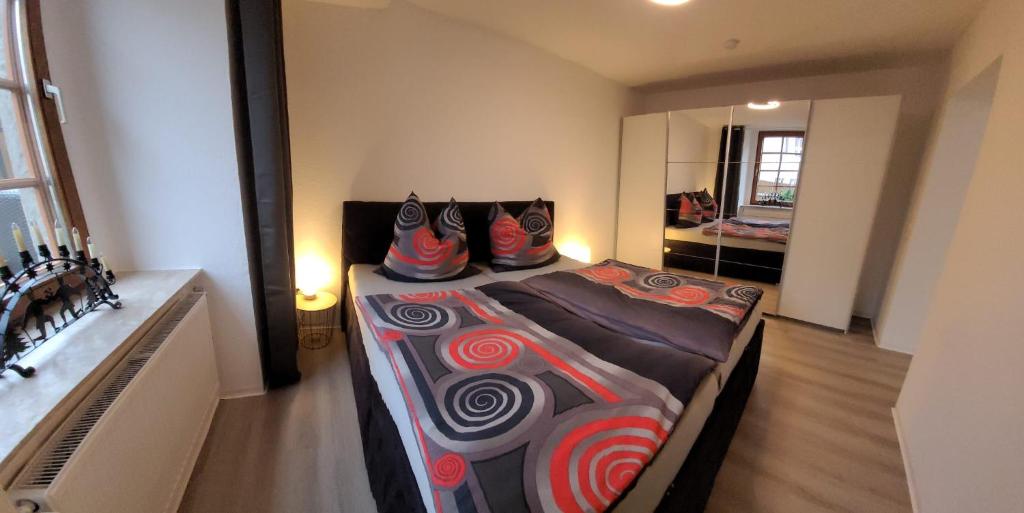 1 dormitorio con 1 cama grande y almohadas coloridas. en Ferienwohnung EG Frauenmarkt 1, en Schneeberg