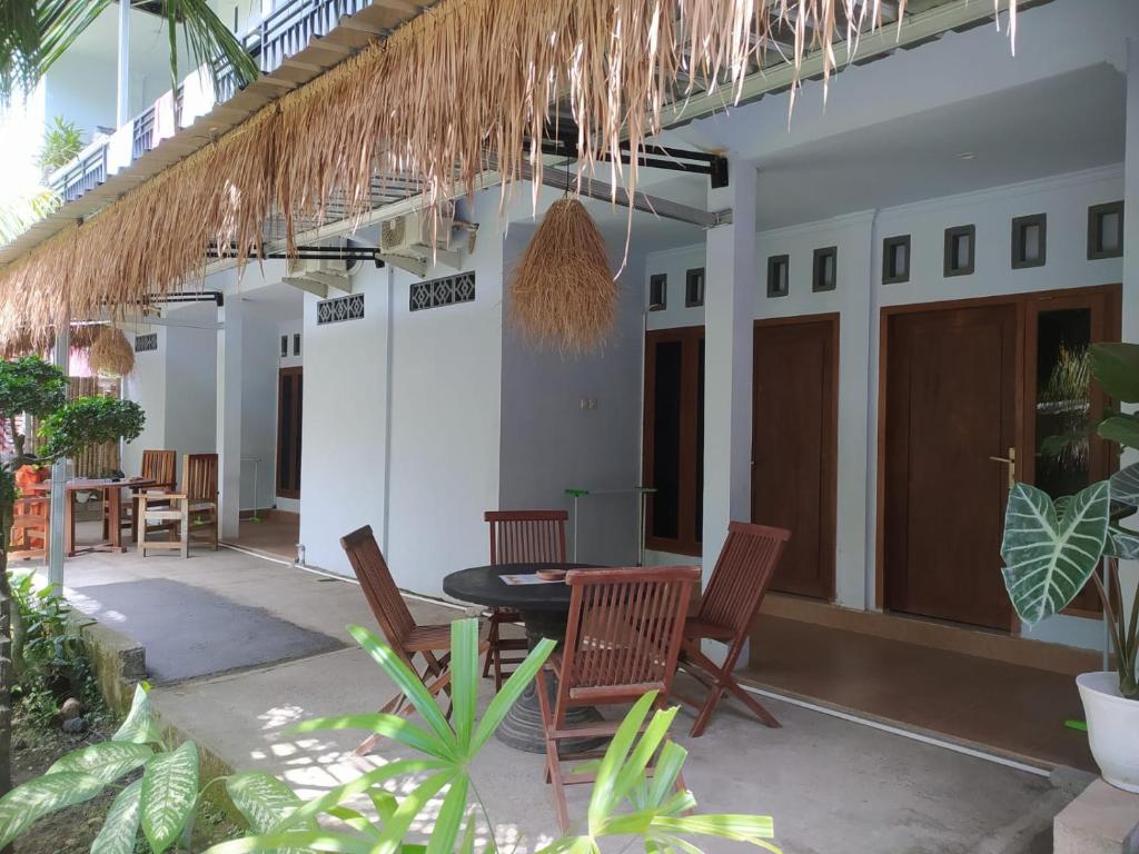 a patio of a house with chairs and a table at Merendeng Hostel Kuta in Kuta Lombok