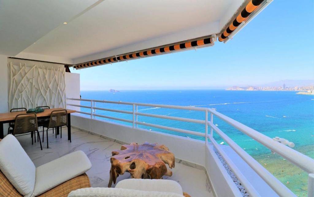 een balkon met een tafel en uitzicht op de oceaan bij Magnificent and Luxury apartment at 22 floor and on the first line at Levante Beach beach in Benidorm