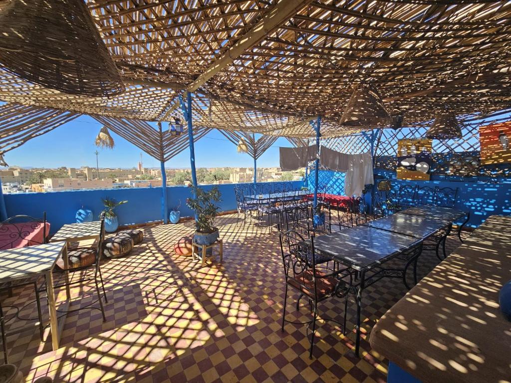 un patio avec des tables et des chaises sous un toit dans l'établissement Panorama chez Hamid, à Moulay Ali Chérif