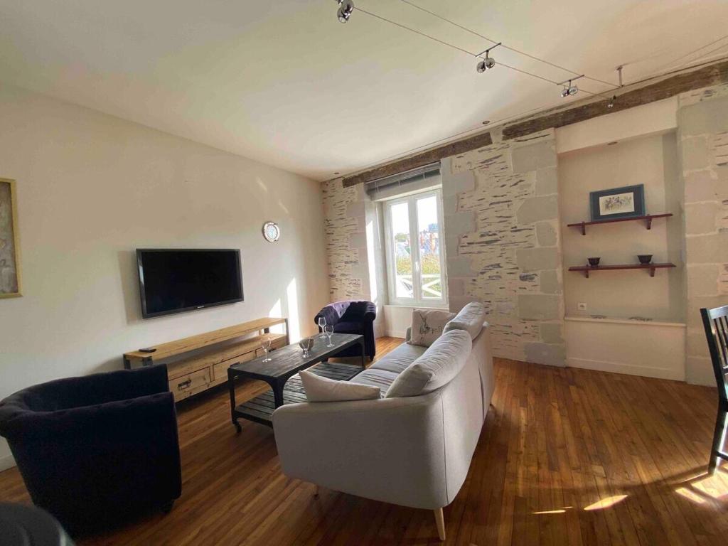een woonkamer met een bank en een tv bij Casa Blancheraie in Angers
