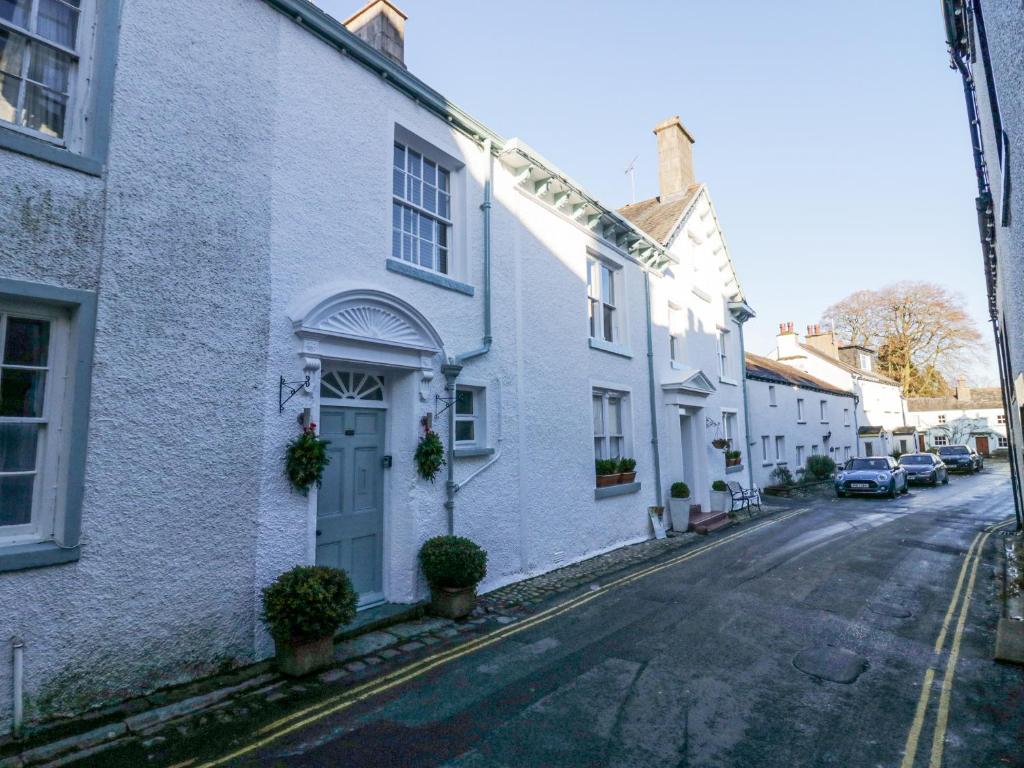 an empty street with white houses on a street at Cartmel Flat in Grange Over Sands