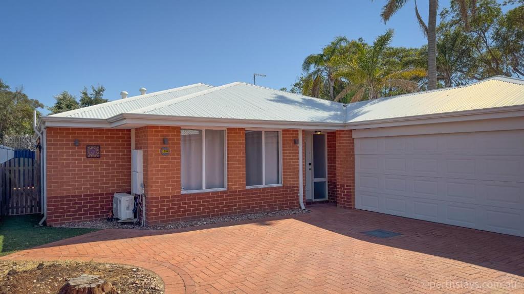 una casa de ladrillo rojo con garaje blanco en Fremantle High Street Retreat, en Fremantle