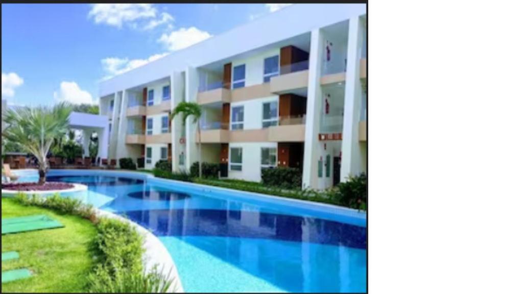 un gran edificio de apartamentos con piscina en Village Condomínio Porto Smeralda - Guarajuba en Guarajuba