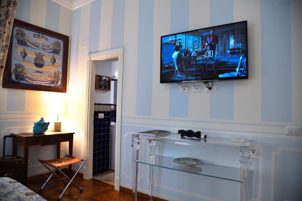 sala de estar con TV de pantalla plana en la pared en Regal House Anzio Manetti 16, en Anzio