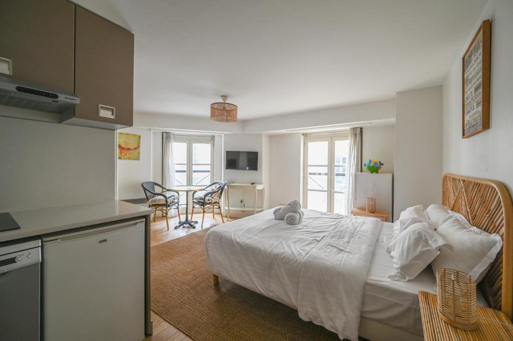 Il comprend une chambre avec un lit et une cuisine avec des chaises. dans l'établissement Paris, Opéra 1... Comme chez soi, à Paris