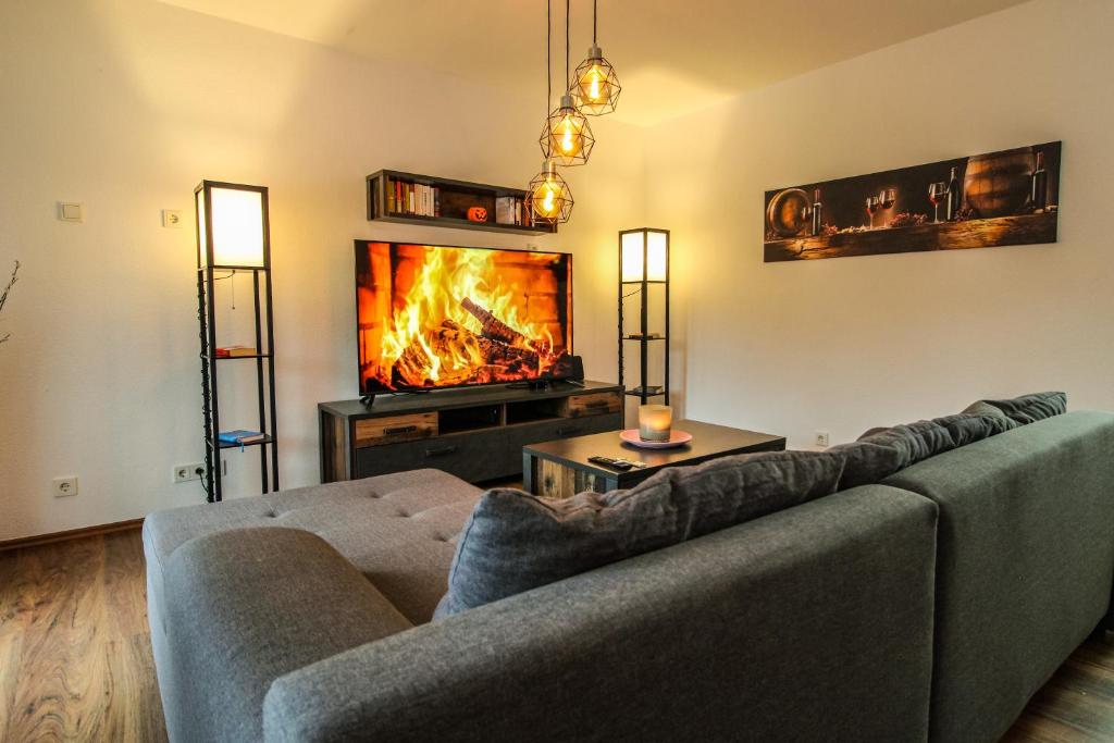 a living room with a couch and a fireplace at Moderne FeWo SKY Netflix Terrasse Burgblick Boxspringbett Waschtrockner in Bullay