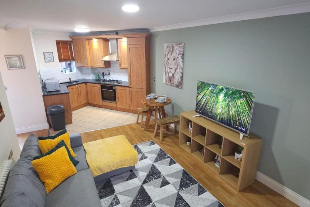 a living room with a gray couch and a kitchen at Modern flat Tower Bridge/Bermondsey in London