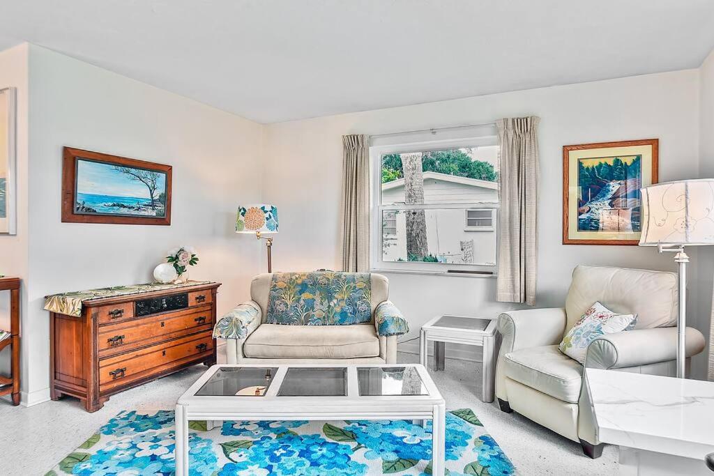 a living room with a chair and a coffee table at Cozy cottage for longer stays! in Vero Beach