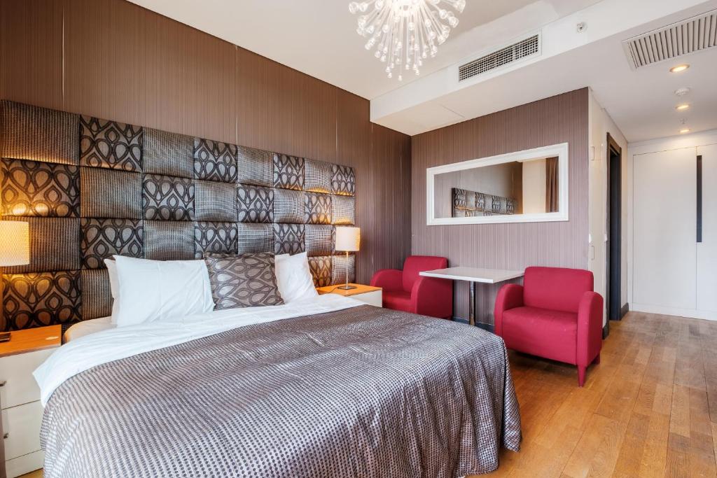 - une chambre avec un lit et deux chaises rouges dans l'établissement Lux Residence w Balcony 1 min to Metro in Merter, à Istanbul