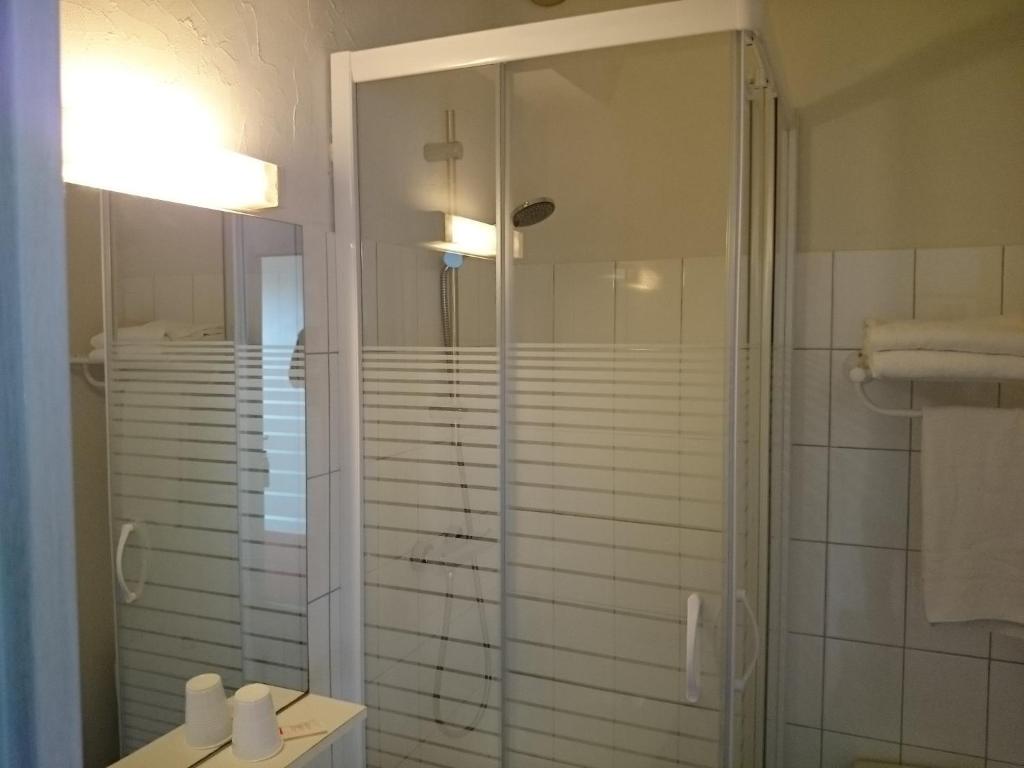 a bathroom with a shower with a glass door at Hotel TGV in Quimper