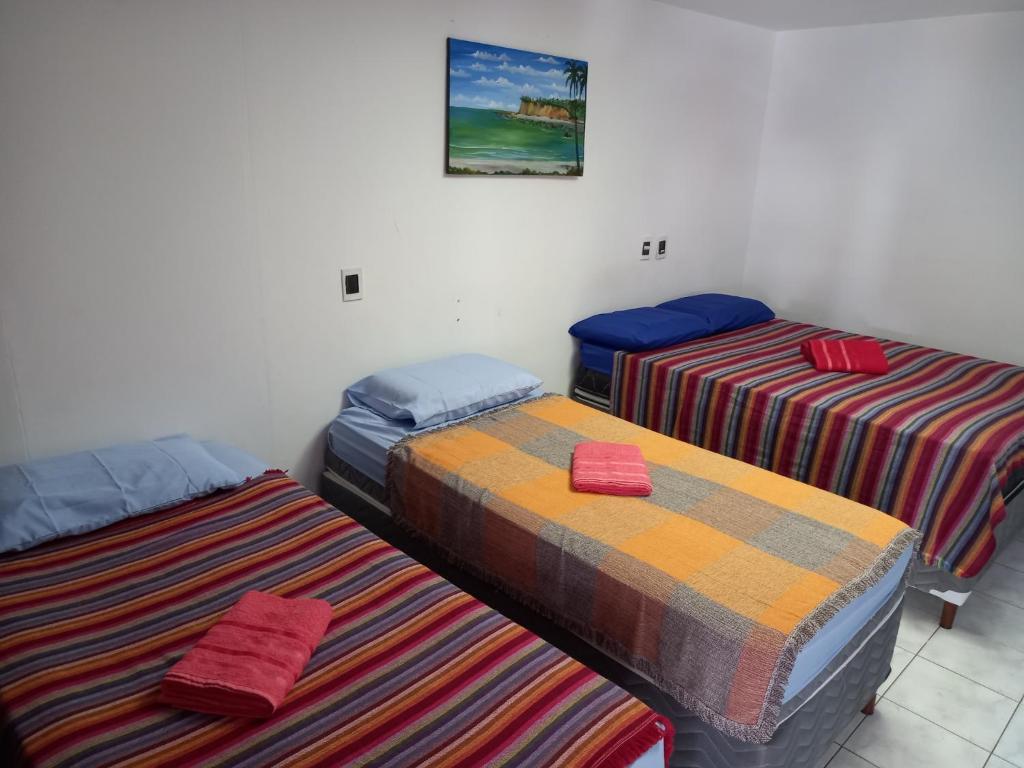 a room with three beds in a room at Pousada Aconchego do Tambaú in João Pessoa