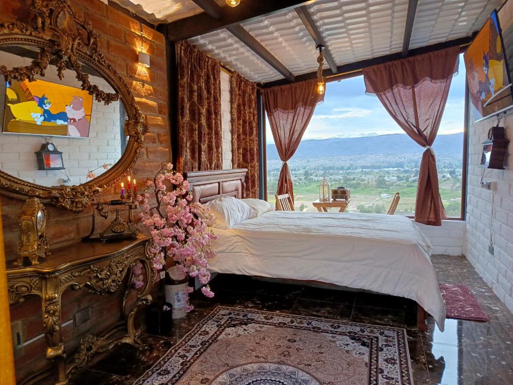 a bedroom with a bed and a large window at Tiny Home Glamping en Latacunga in Latacunga