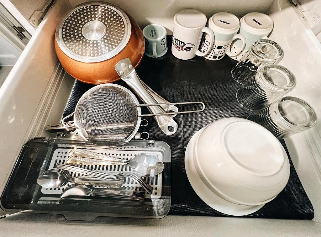 a kitchen sink with dishes and a strainer at KPlace Staycation at Azure North in San Fernando