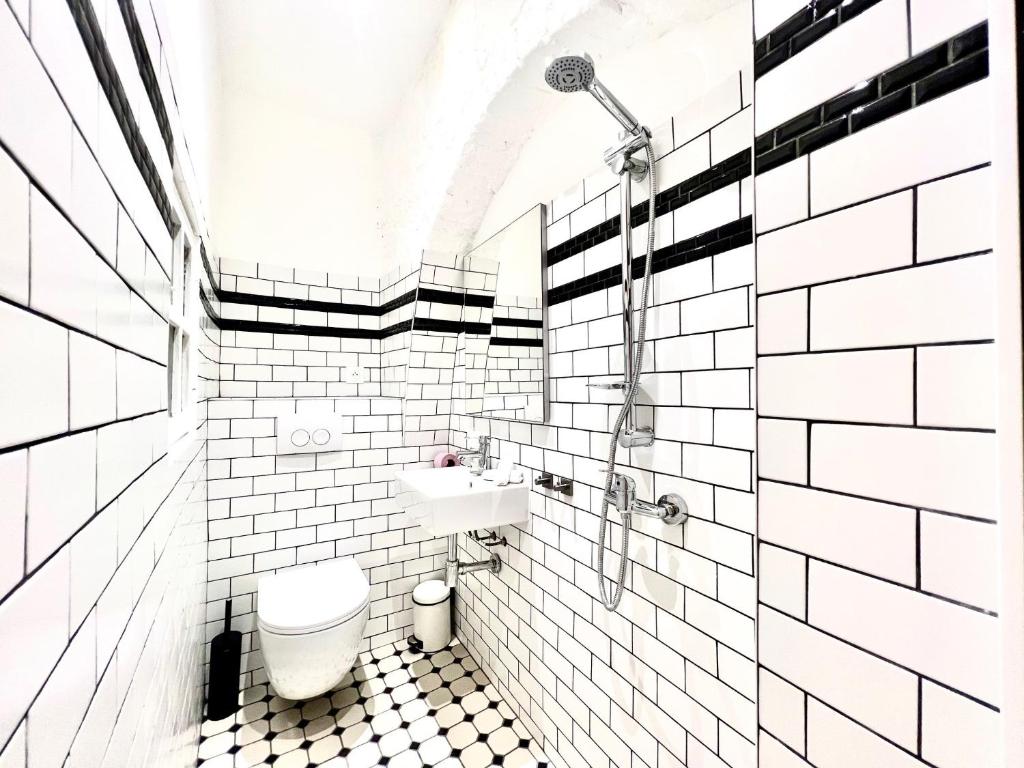 a white tiled bathroom with a toilet and a sink at ApartHotel Riviera - CCC OT Loft du Chateau Old Town Prom des Anglais in Nice