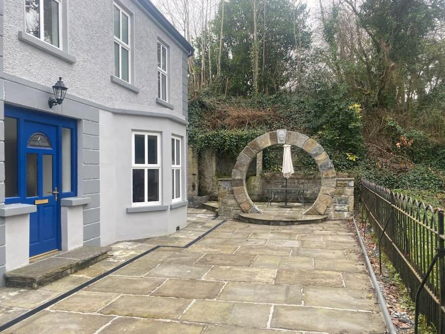 uma casa com uma porta azul e uma entrada de pedra em Carefully renovated traditional Irish Town-house em Lisdoonvarna