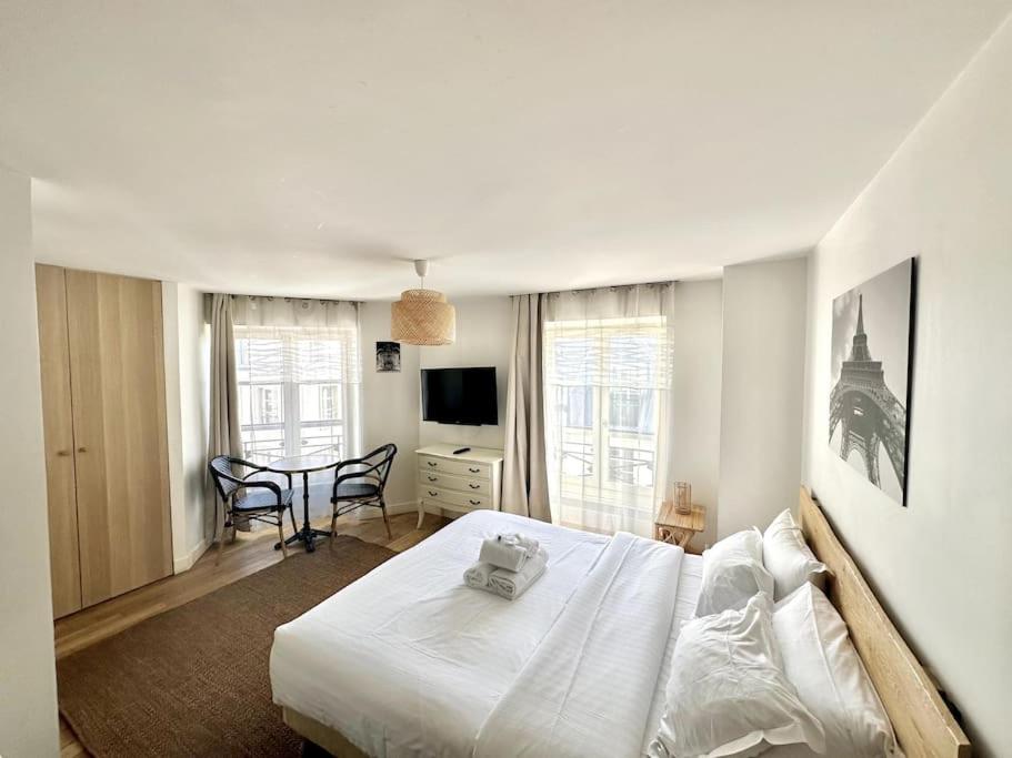- une chambre avec un lit blanc, une table et des chaises dans l'établissement Paris, Opéra 5...Charming apartment in Paris, à Paris