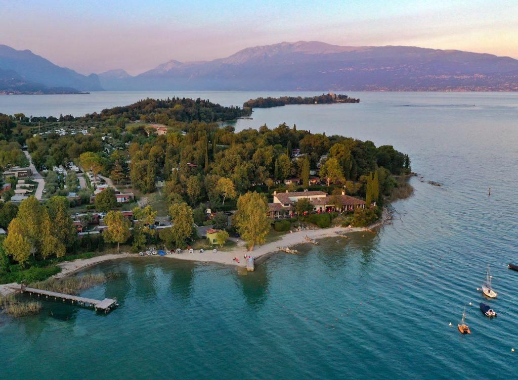 an island in the middle of a body of water at Fornella Camping & Wellness family resort in San Felice del Benaco