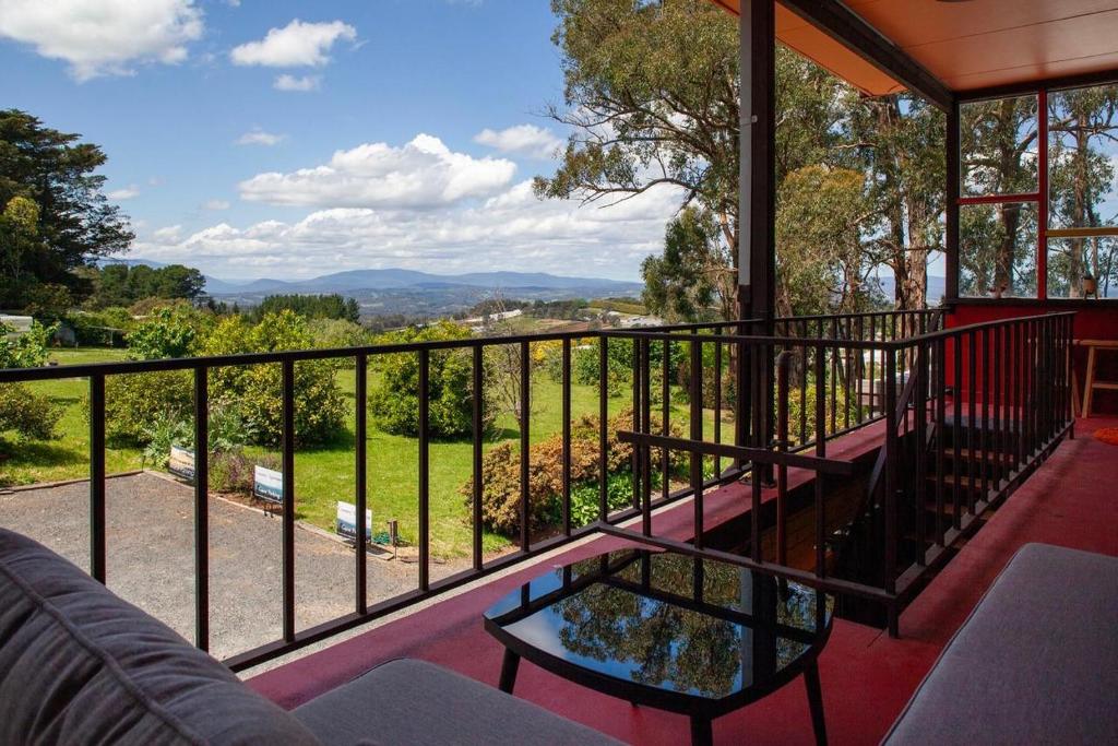 - Balcón de casa con sofá y mesa en Vista Suite Treetops Silvan Valley Lodge en Silvan