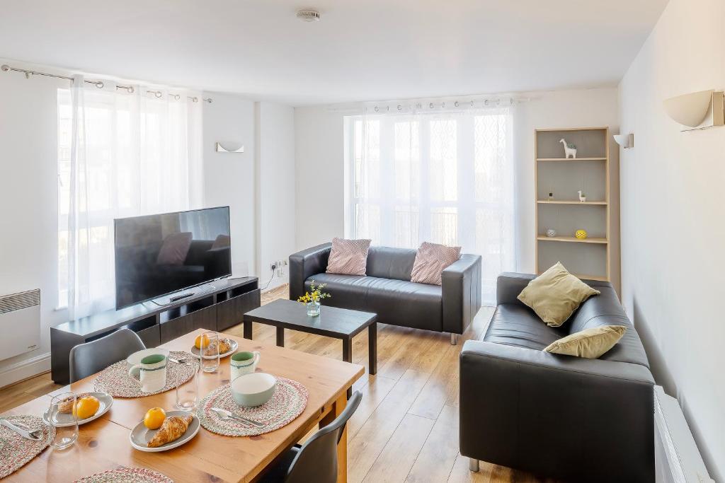 a living room with a couch and a table at The Bright Flat in Whitechapel in London