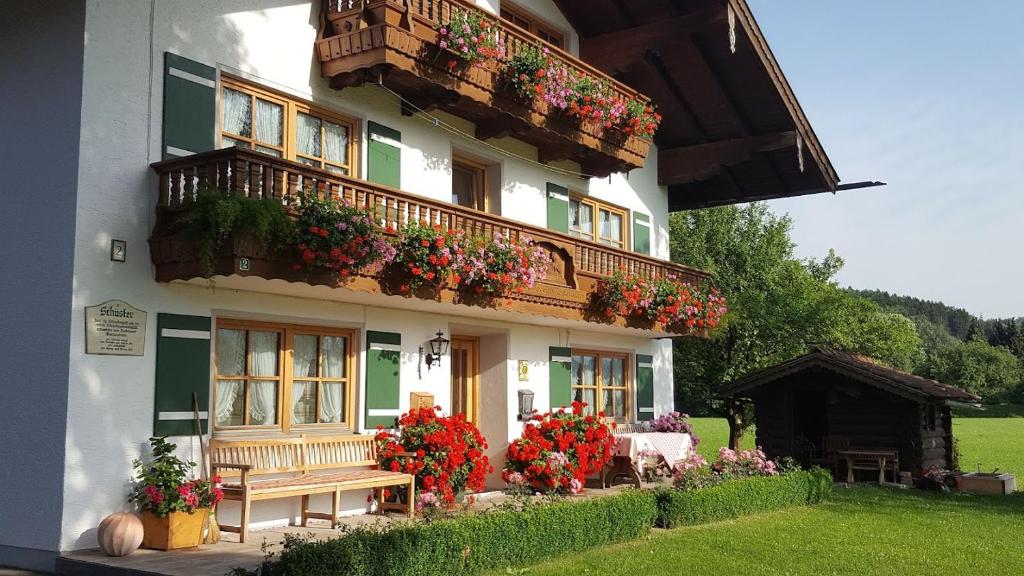 a building with a balcony with flowers on it at Schusterhof in Marquartstein