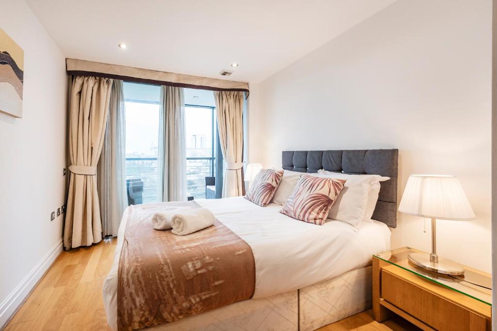 a bedroom with a large bed and a window at Modern Paddington Station 2 Bedroom Apartment in London