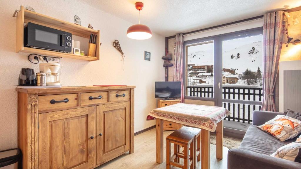 een woonkamer met een bank, een tafel en een tv bij LE VERNON 1027 Appt premium 4 pers in Chamrousse