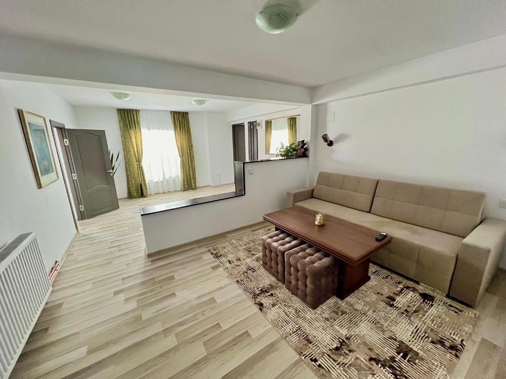 ein Wohnzimmer mit einem Sofa und einem Tisch in der Unterkunft Parc Vatra Dornei 1 - Family, couples & groups in Vatra Dornei